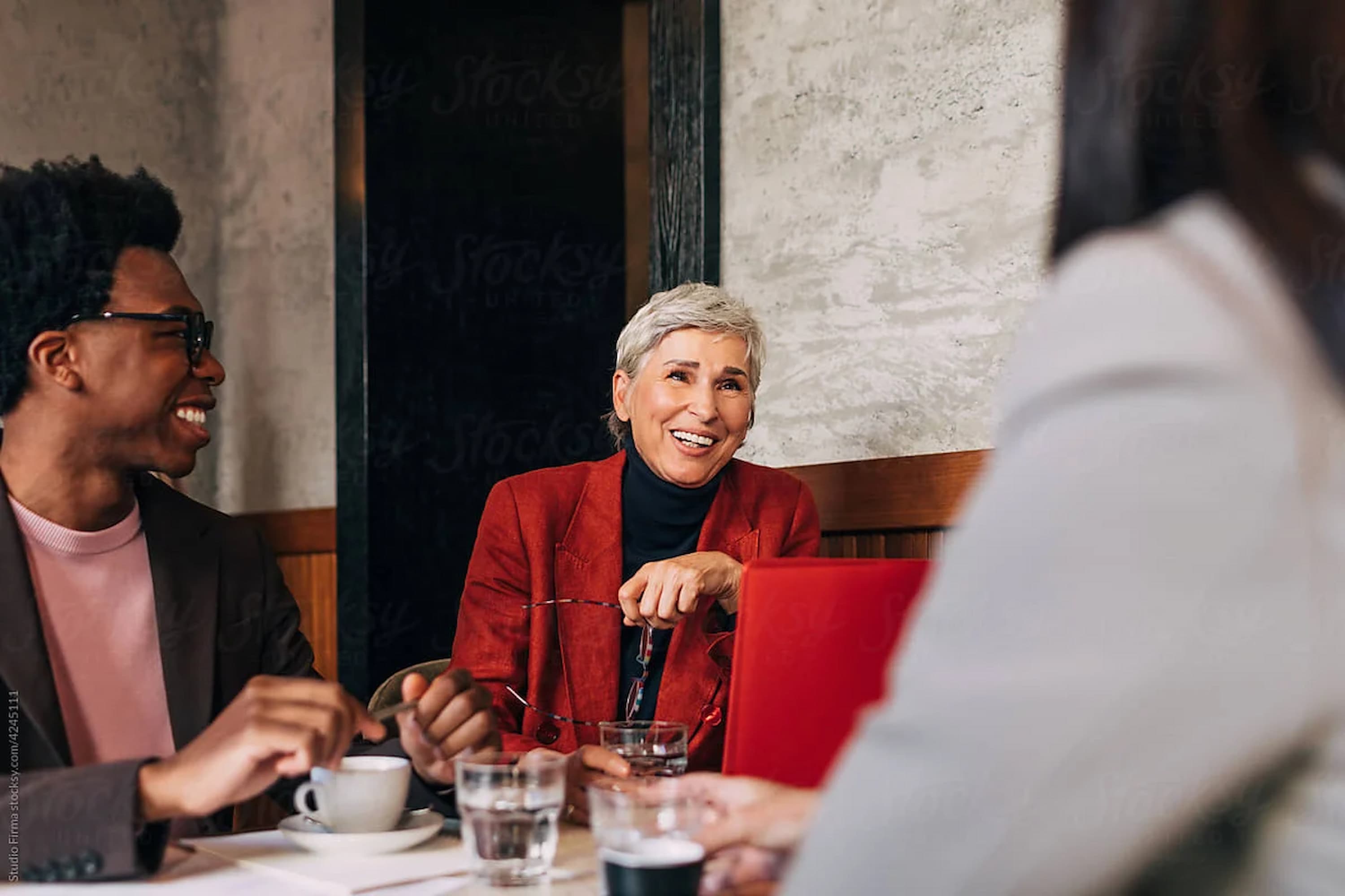 Seasoned executives in warm conversation over coffee